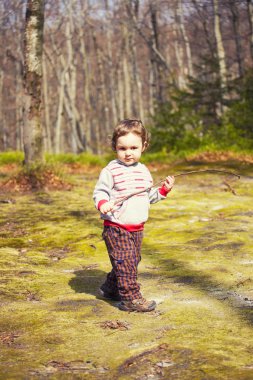Ormanda oynayan küçük bir çocuk.