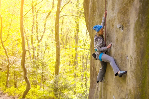 Het meisje klimt op de rots. — Stockfoto