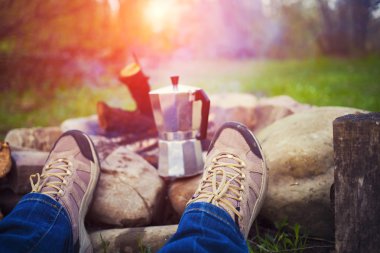 Ateşin yanında oturan insanlar.