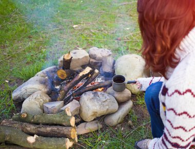 Ateşin yanında oturan insanlar.