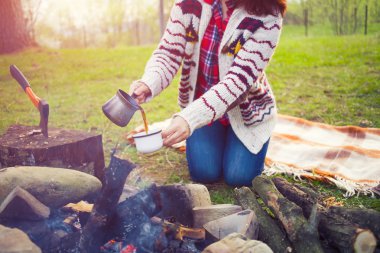 Kız doğada kahve hazırlar.
