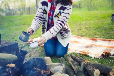 Kız doğada kahve hazırlar.