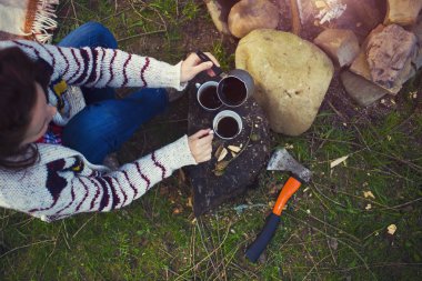 Kız doğada kahve hazırlar.