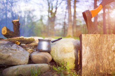 Bir kahve makinesi ve bir balta bir ateş yakın.