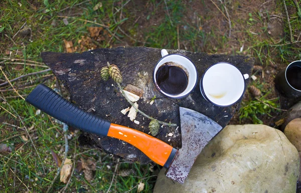 A coffee maker and an axe near a fire. — Stock Photo, Image