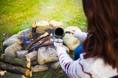 Kız doğada kahve hazırlar.