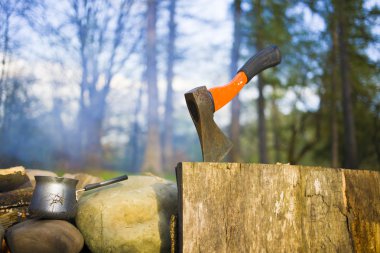 Bir kahve makinesi ve bir balta bir ateş yakın.