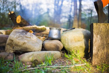 Bir kahve makinesi ve bir balta bir ateş yakın.