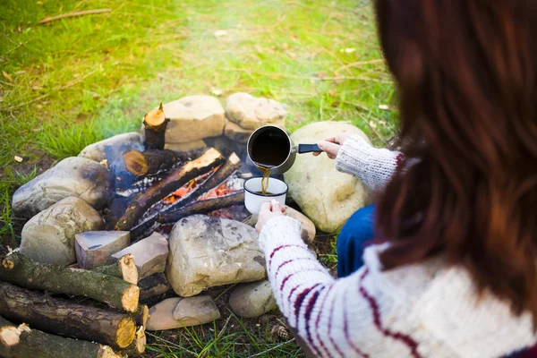 Kız doğada kahve hazırlar.
