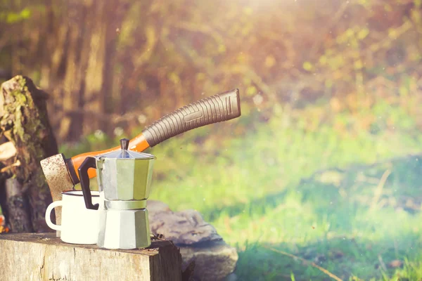 Bir kahve makinesi ve bir balta bir ateş yakın.