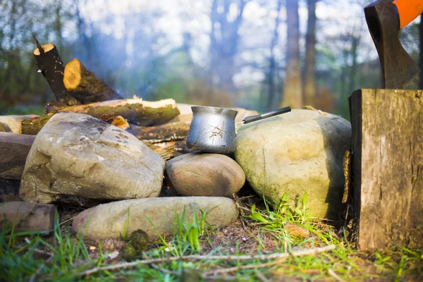 Bir kahve makinesi ve bir balta bir ateş yakın.