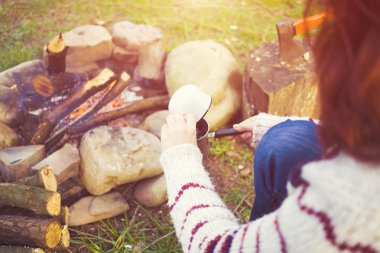 Kız doğada kahve hazırlar.