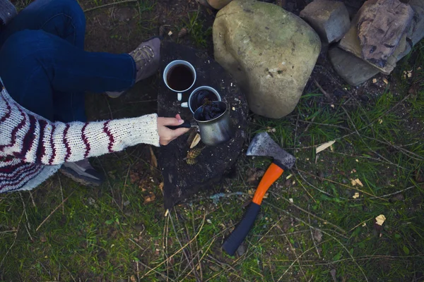 Kız doğada kahve hazırlar.