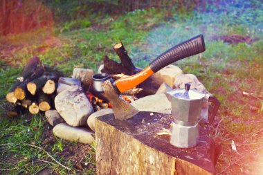 Bir kahve makinesi ve bir balta bir ateş yakın.