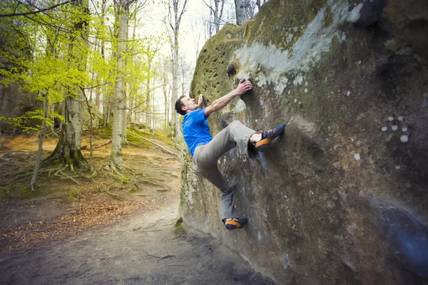 Wspinacz jest bouldering na skałach. — Zdjęcie stockowe