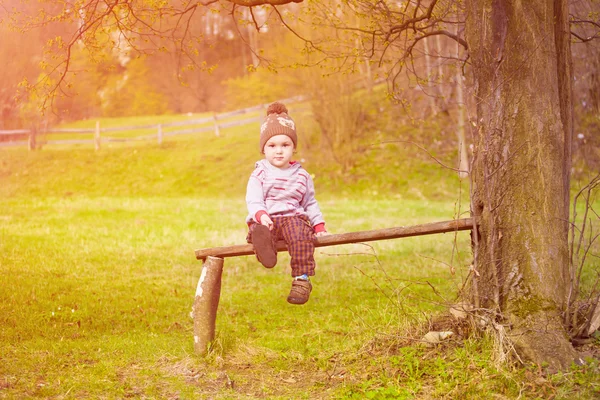 Un niño está sentado debajo de un árbol. . —  Fotos de Stock