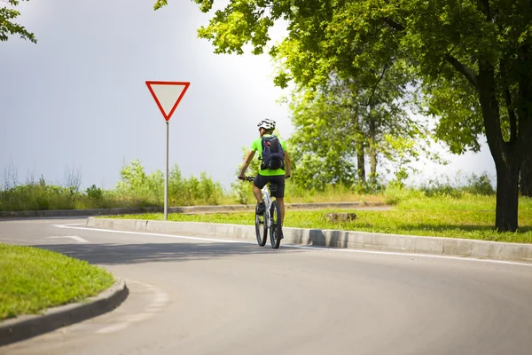 Ein Mann auf einem Fahrrad mit einem Rucksack. — Stockfoto