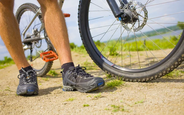 Der Biker steht neben seinem Fahrrad. — Stockfoto