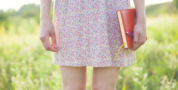 Flicka i sommarklänning håller en bok. — Stockfoto