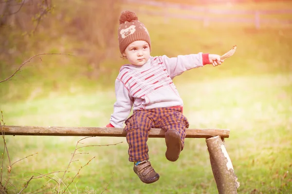 Un niño está sentado debajo de un árbol. . —  Fotos de Stock