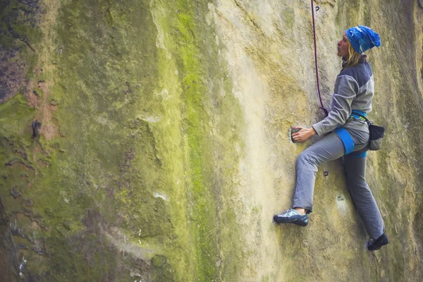 Tyttö kiipeää kalliolle . — kuvapankkivalokuva