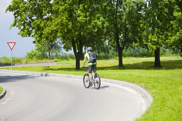 A man on a Bicycle with a backpack. — Stock Photo, Image