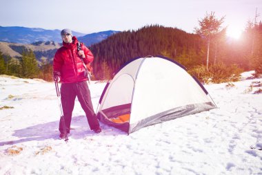 Dağcı çadırın yakınında bir sırt çantası ile.