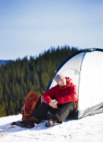 Альпинист сидит рядом с палаткой . — стоковое фото