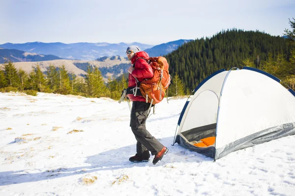 Альпинист с рюкзаком возле палатки . — стоковое фото