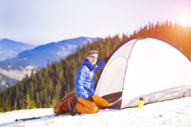 Dağcı çadırın yakınında bir sırt çantası ile.