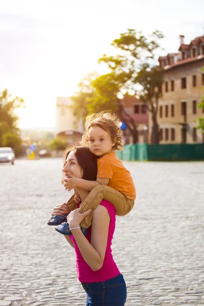 Το παιδί κάθεται πάνω στους ώμους της μαμάς. — Φωτογραφία Αρχείου