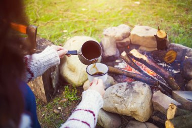 Kız doğada kahve hazırlar.