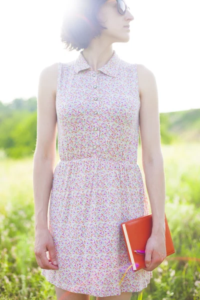 Dziewczyna w sukience lato z książką w ręku. — Zdjęcie stockowe