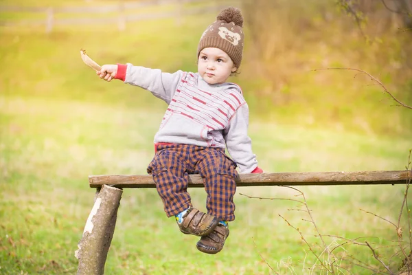 Un niño está sentado debajo de un árbol. . —  Fotos de Stock