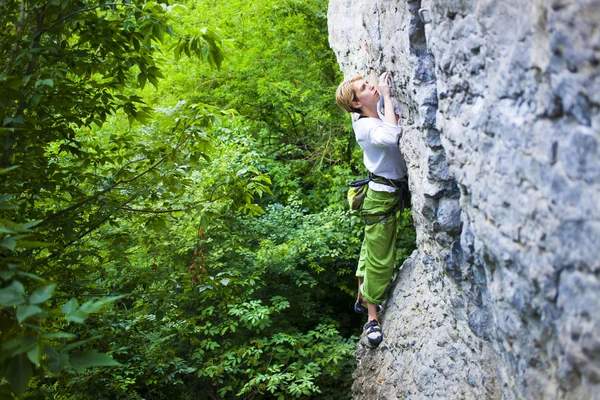 Das Mädchen erklimmt den Felsen. — Stockfoto