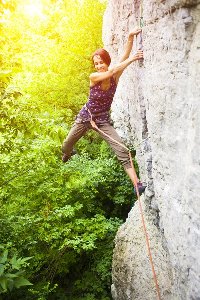 Das Mädchen erklimmt den Felsen. — Stockfoto