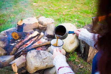 Kız doğada kahve hazırlar.