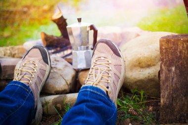 Ateşin yanında oturan insanlar.