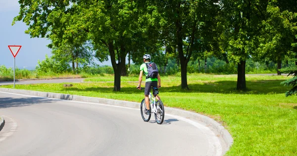 Ein Mann auf einem Fahrrad mit einem Rucksack. — Stockfoto