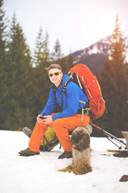 Uzun yürüyüşe çıkan kimse ile bir yürüyüş sırasında dinlenme sırt çantası.