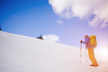 Dağcı karlı bir yamaçta yürür.