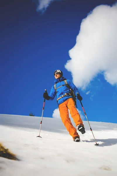 Escalador de montaña camina en una ladera nevada . — Foto de Stock