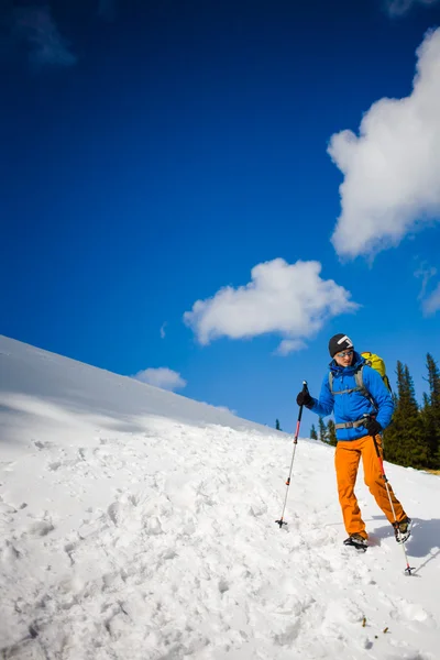 Alpiniste marche sur une pente enneigée . — Photo