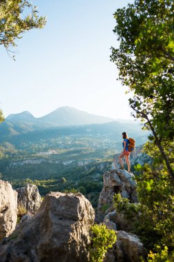 Sırt çantalı bir kadın dağın tepesinde durur ve bir dağ vadisinin güzelliğine hayran kalır, güzel yerlere seyahat eder, hedefe ulaşır, güzel manzara, Türkiye 'de seyahat eder..