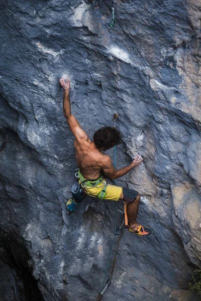 A strong man climbs a rock, Strong back muscles, Rock climbing in Turkey, Training endurance and strength, man in extreme sport, Rock climber is training in nature.