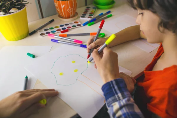 art lesson. individual lesson with a teacher. a child with a teacher is engaged in art therapy