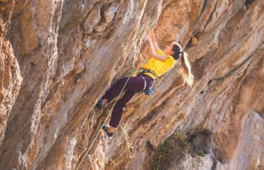 Bir kız kayaya tırmanıyor. Sporcu doğada antrenman yapar. Kadınlar zor tırmanış rotalarının üstesinden gelir. Güçlü bir dağcı. Olağanüstü bir hobi. Türkiye 'de kaya tırmanışı.