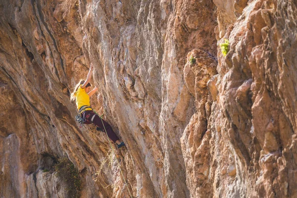 一个女孩爬上岩石 运动员在大自然中训练 女人克服了艰难的攀登路线 强壮的登山者极端的嗜好土耳其的攀岩 — 图库照片