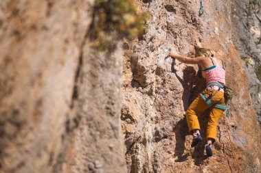 Bir kız kayaya tırmanıyor. Sporcu doğada antrenman yapar. Kadınlar zor tırmanış rotalarının üstesinden gelir. Güçlü bir dağcı. Olağanüstü bir hobi. Türkiye 'de kaya tırmanışı.