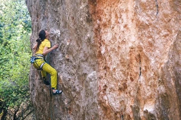 一个女孩爬上森林背景上的岩石 运动员在大自然中训练 女人克服了艰难的攀登道路 坚强的攀登者 极端的爱好 土耳其的攀岩 — 图库照片